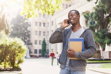 Genç öğrenci parkta smartphone cep telefonu ile konuşmak