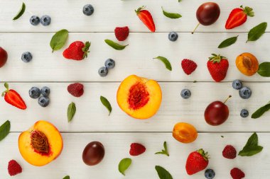 Beyaz ahşap masa üstü görünümünde çeşitli meyveler