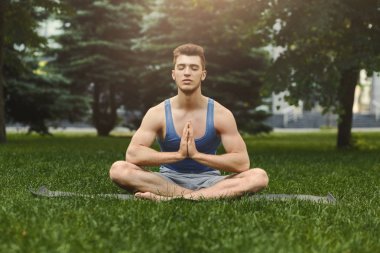 Pratik yoga padmasana içinde oturan genç adam
