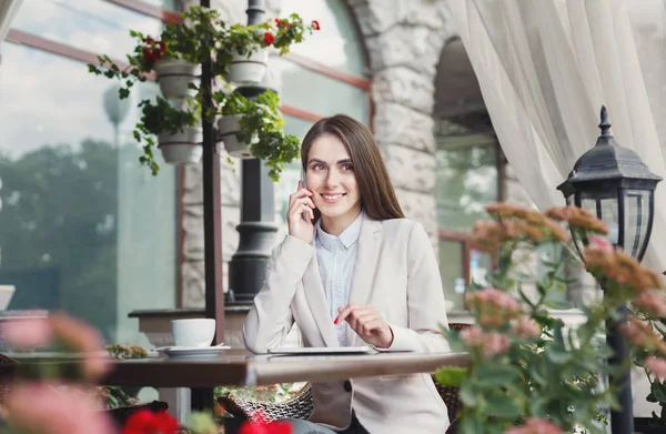 Jonge zakenvrouw praten over telefoon buitenshuis — Stockfoto