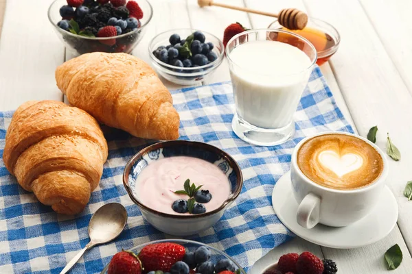 Continental breakfast with croissants and berries on checkered c