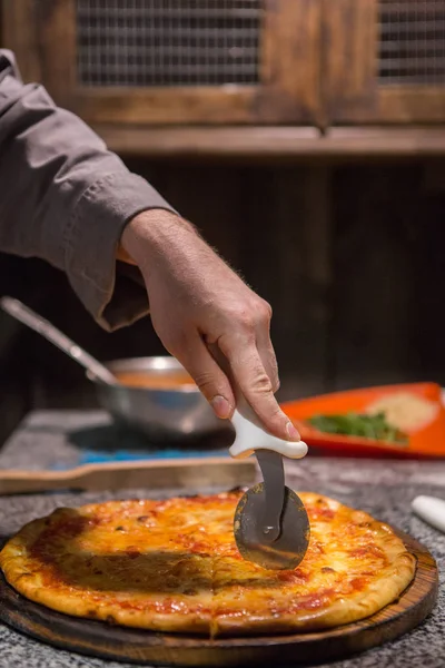 Koch benutzt Pizzarad — Stockfoto