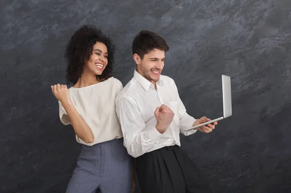 Paar mit Laptop auf grauem Hintergrund — Stockfoto