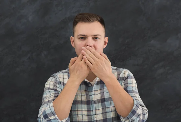 Молодий чоловік покриває рот руками — стокове фото