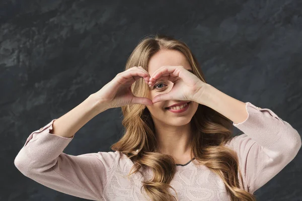 Glückliche Frau macht Herz mit ihren Fingern — Stockfoto