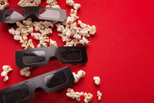 3D brýle a popcorn na červeném pozadí — Stock fotografie
