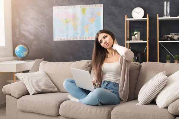 Tired woman working on laptop at home