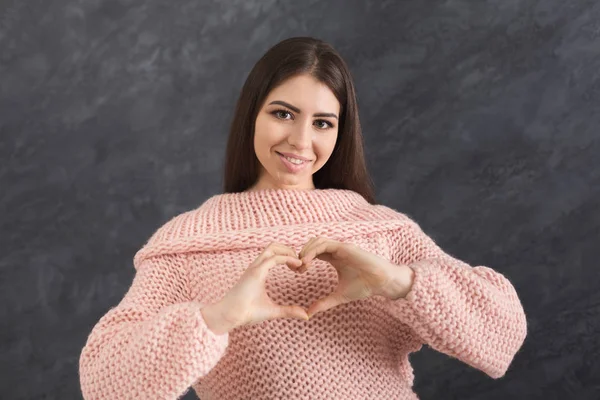 Glückliches Mädchen macht Herz mit ihren Fingern — Stockfoto