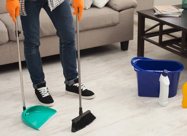 Jonge man huis schoonmaken, vegen — Stockfoto