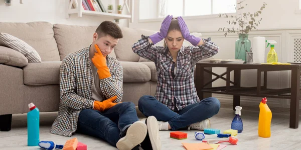 Shocked couple cleaning house with lots of tools — Stock Photo, Image