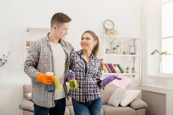 Молода пара тримає прибиральне обладнання вдома — стокове фото