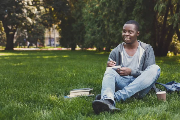 Jovem escrevendo em livro-cópia ao ar livre — Fotografia de Stock