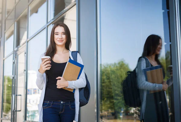 Junge Studentin mit Büchern und Rucksack. Vor dem Unterricht draußen bleiben und Kaffee trinken — Stockfoto