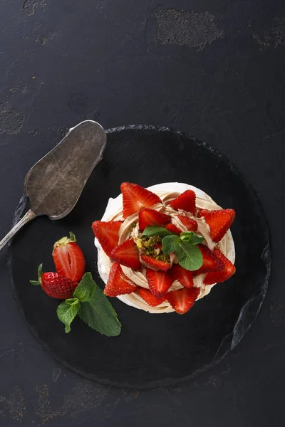 Delicioso bolo de merengue Anna Pavlova com morango sobre fundo preto — Fotografia de Stock