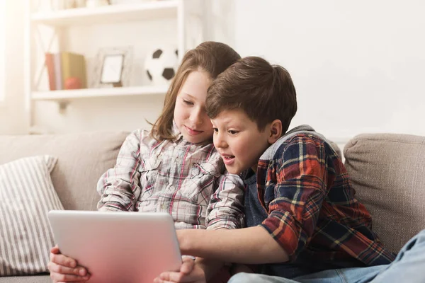 Twee kinderen met gadgets op de Bank thuis — Stockfoto