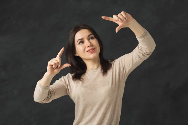 Nadenkend meisje gebaar maken op zwarte achtergrond — Stockfoto