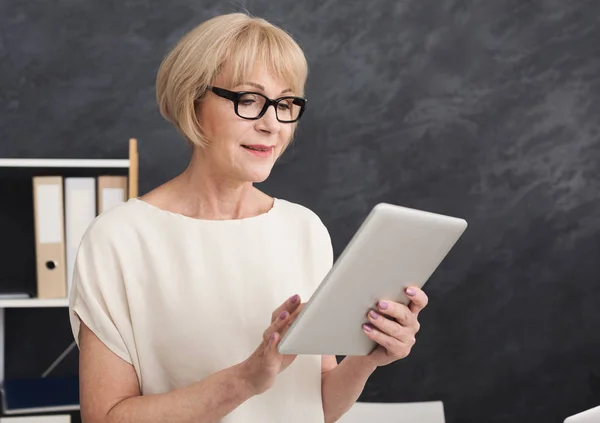 Happy businesswoman at work using digital tablet