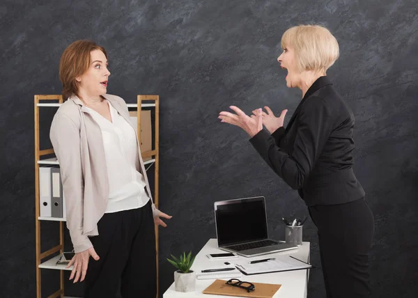 Angry middle aged boss yelling at young employee — Stock Photo, Image