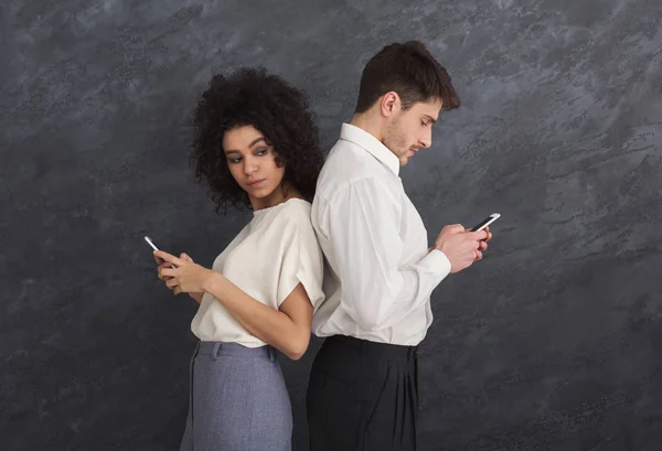 Jealous girlfriend watching guy texting on phone — Stock Photo, Image
