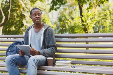 Konsantre adam açık havada onun tablet üzerinde çalışan