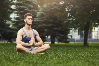 Pratik yoga padmasana içinde oturan genç adam