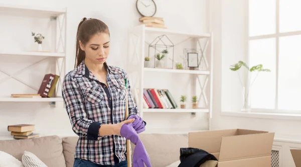 Vrouw beschermende handschoenen dragen voordat u gaat schoonmaken — Stockfoto