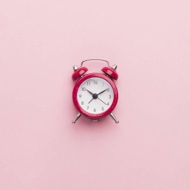 Pembe arka planda kırmızı oyuncak alarm saati
