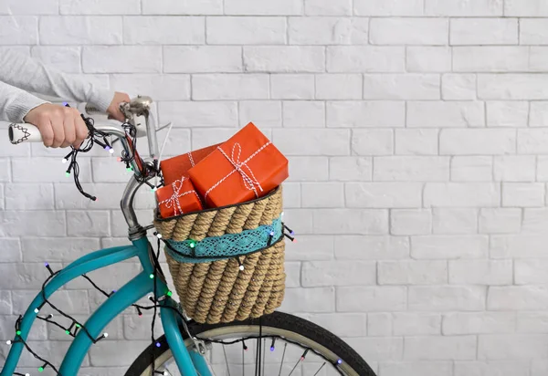 Unrecognizable woman riding a bicycle with Christmas presents — Stock Photo, Image