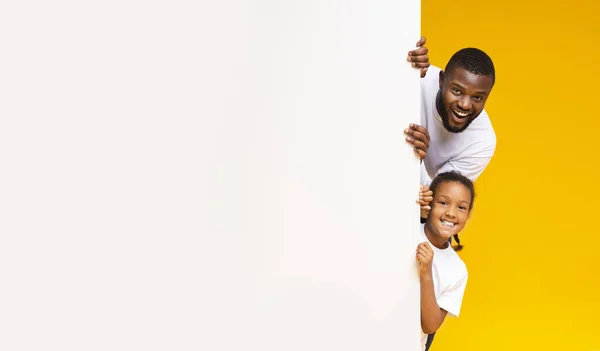 黒人の父と娘が白い広告板を覗き見 — ストック写真