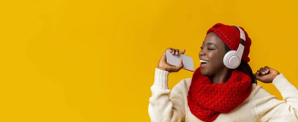 穿着无线耳机的无忧无虑的冬季女孩在电话中歌唱 — 图库照片