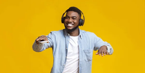 Чорний хлопець танцює, слухаючи свою улюблену музику в навушниках — стокове фото