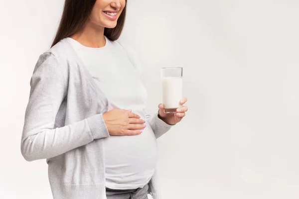 Wanita hamil Memegang Kaca Dari Susu Berdiri Atas Latar Belakang Merah Muda — Stok Foto