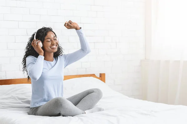 Menina muito negra ouvindo música e dançando na cama — Fotografia de Stock