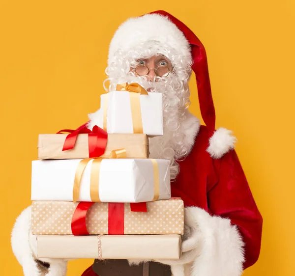 Weihnachtsmann mit Geschenkschachteln für Kinder auf Orange — Stockfoto