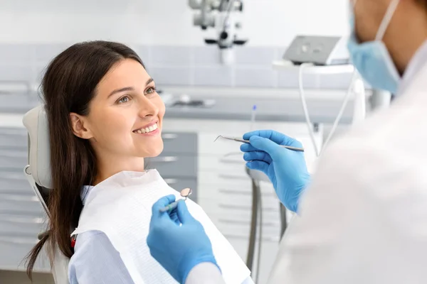 Mulher bonita olhando para o dentista com confiança — Fotografia de Stock