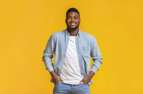 Portrait of handsome black guy standing with hands in pockets — Stock Photo, Image