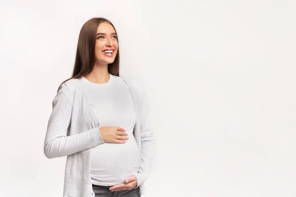 Happy těhotná dáma dotýkající se břicho stojící, studio shot — Stock fotografie