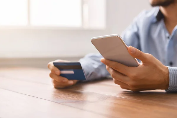 Uomo che utilizza carta di credito e smartphone per lo shopping online — Foto Stock