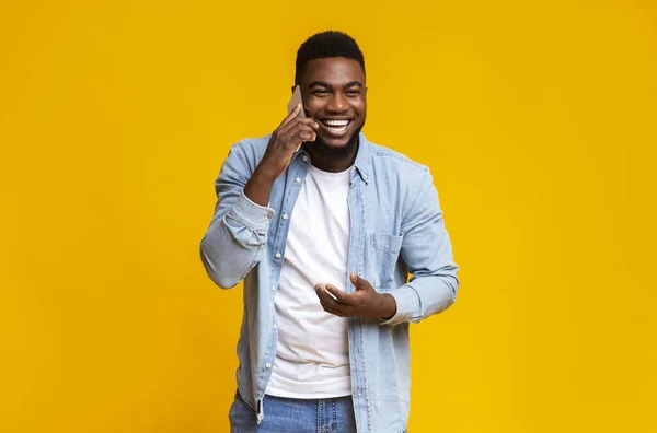 Cheerful black guy talking on phone and laughing out loud — Stock Photo, Image