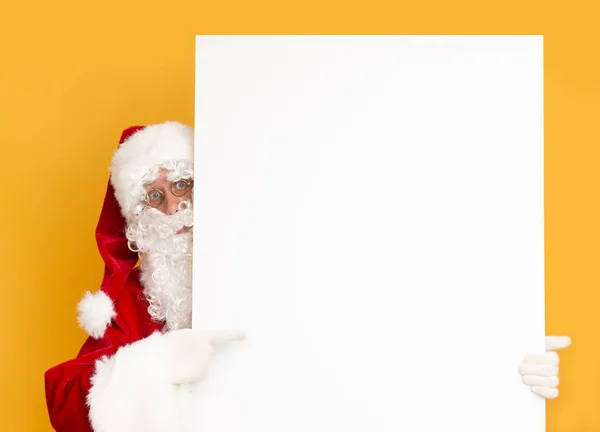 Père Noël montrant sur feuille blanche vierge de papier pour les salutations — Photo