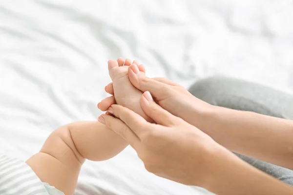 Mãe massagear pequenos bebês pé, fazendo fortalecimento ginástica — Fotografia de Stock