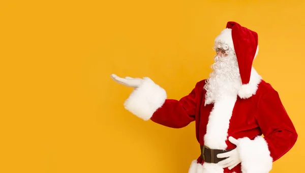 Άγιος Βασίλης δείχνει στο χώρο αντίγραφο για διαφήμιση σε πορτοκαλί — Φωτογραφία Αρχείου