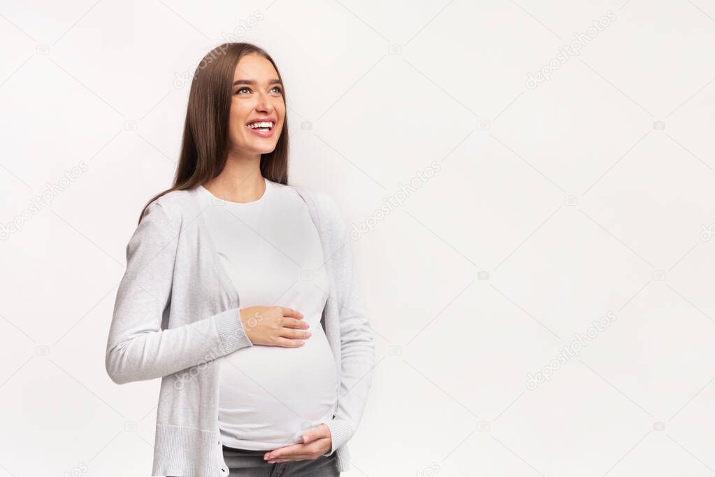 Happy Pregnant Lady Touching Belly Standing, Studio Shot
