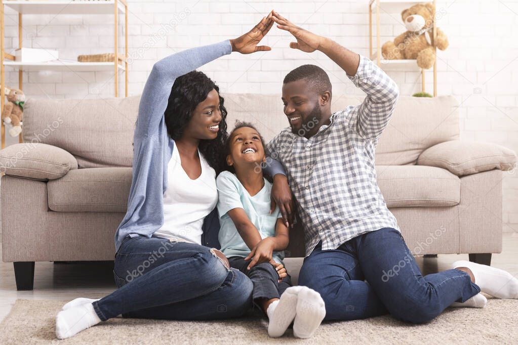 Black family making symbolic roof of hands above little girl