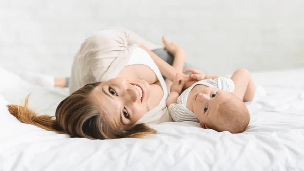 Szczęśliwa piękna mama relaks z dzieckiem w łóżku — Zdjęcie stockowe