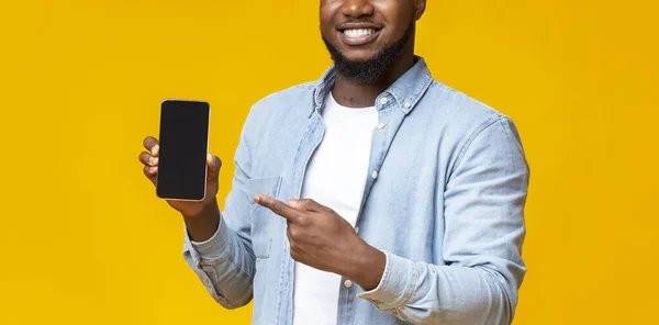Chlápek držící mobil s černou obrazovkou a ukazující na něj — Stock fotografie