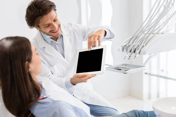 Jóképű fogorvos mutatja üres digitális tabletta képernyő — Stock Fotó