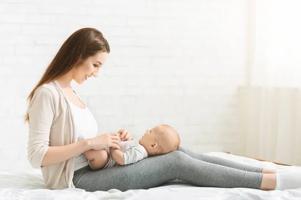 Millennial mom spending time with her newborn baby at home. — Stockfoto