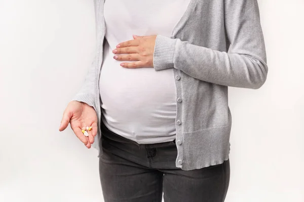 Wanita hamil yang tak dikenali Menampilkan Pil Menyentuh Perut Di Studio, Dipotong — Stok Foto