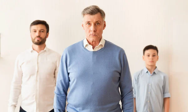 Serious Grandfather With Son And Grandson Standing Against Wall Indoor — Stock Photo, Image